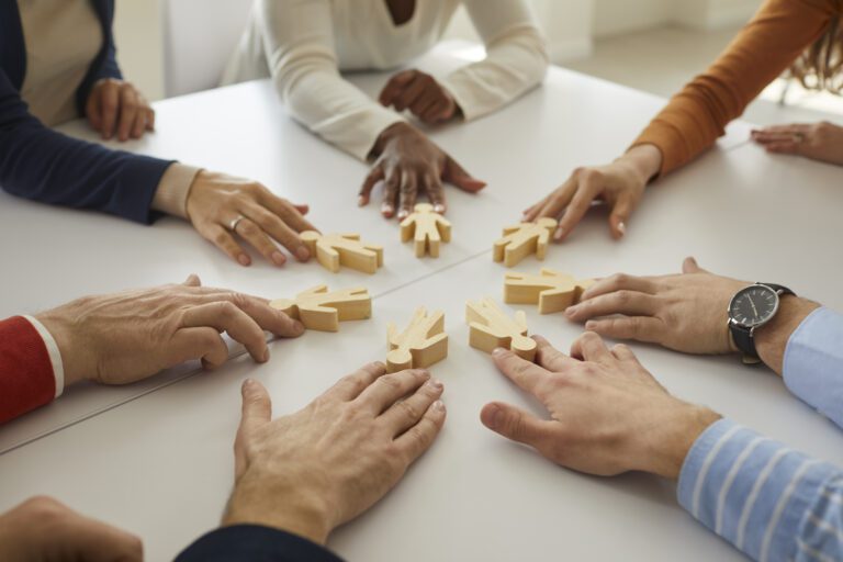 Group of business people join little human figures as symbol of community and teamwork
