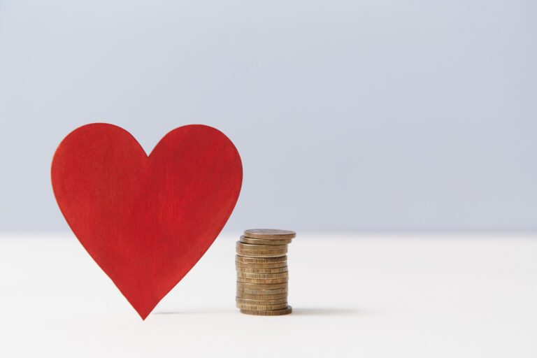 Read heart and stack of coins, copy space. Value of love. Money vs love mockup for design. Relationship versus cash